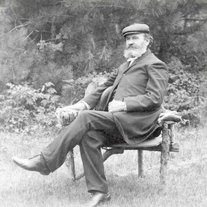 Picture of a bearded A. B. Simpson sitting on a bench