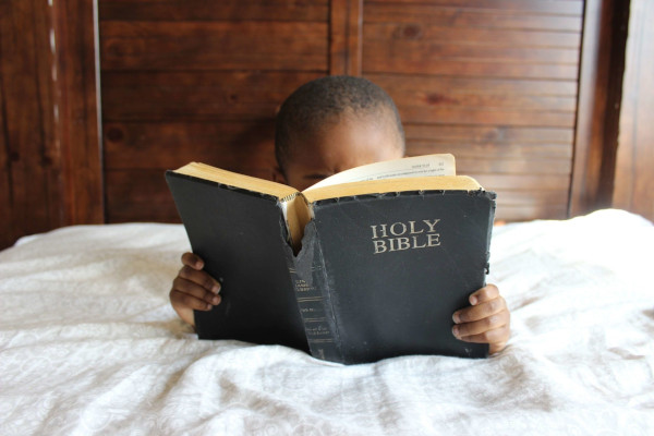 Boy reading Bible in Bed